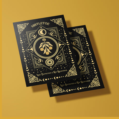 Elegant mistletoe-themed greeting card featuring gold detailing on a dark background with intricate celestial patterns. The text reads: 'Love, Protection & New Beginnings.' Inside message describes ancient Druid mistletoe traditions for blessings and prosperity in the New Year, with instructions for Winter Solstice use and symbolic burning for love and success throughout the year.